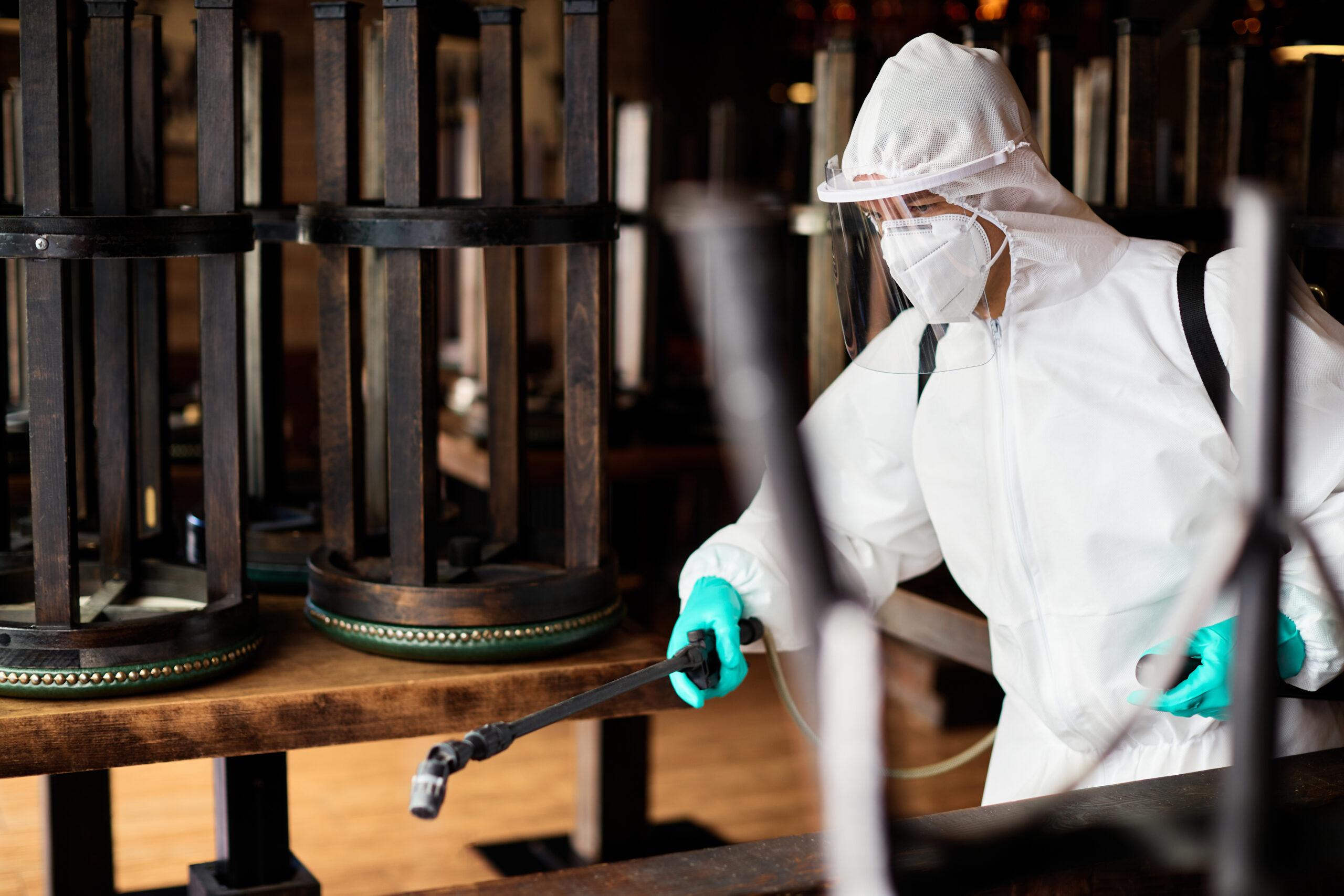 Un travailleur du secteur de la désinfection porte un costume Hazmat pour pulvériser de l'eau contaminée dans un café en raison de l'épidémie de coronavirus.